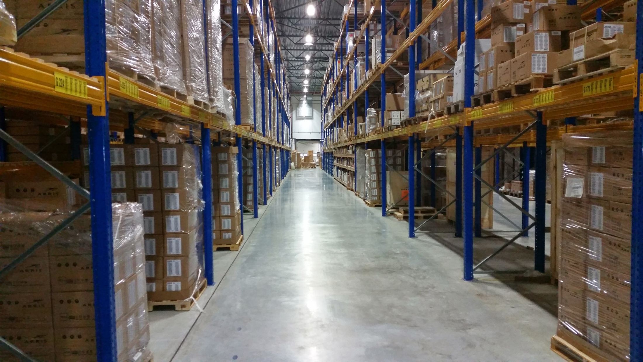 Warehouse aisle lined with blue and yellow pallet racks